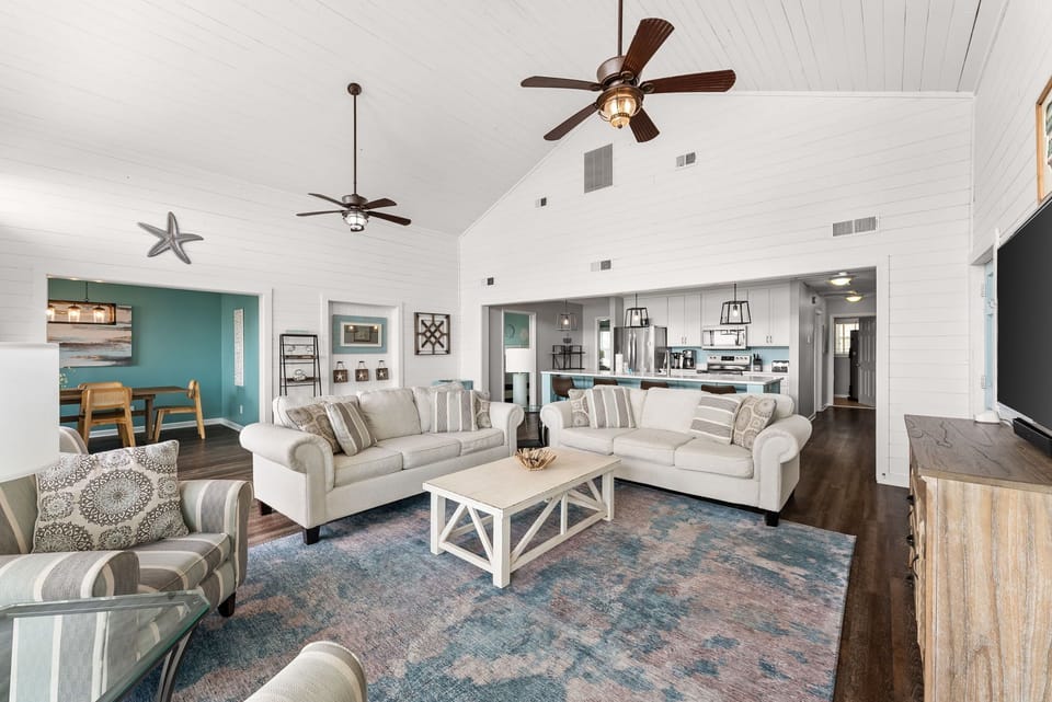 Relax in your spacious living room with vaulted ceilings, coastal decor, and open kitchen views—perfect for gathering with family.