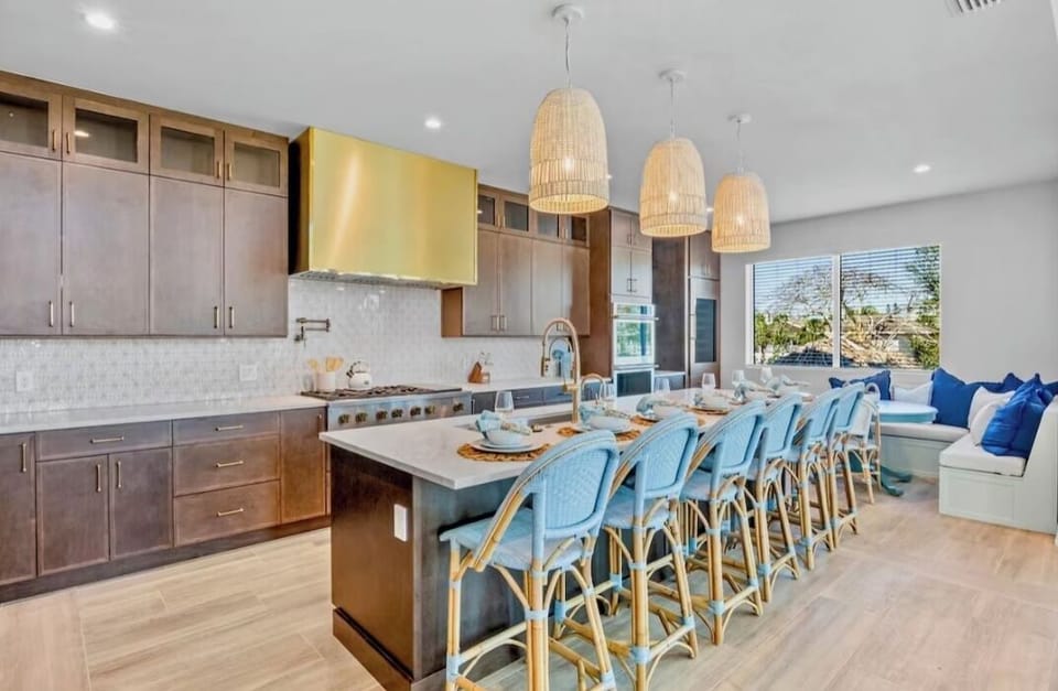 Your dream kitchen awaits with a spacious island, sleek appliances, and coastal-inspired seating where morning coffee feels like a retreat.