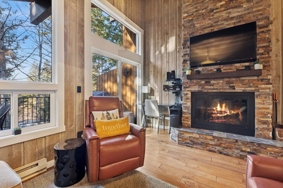 Curl up in your cozy leather chair by the crackling fireplace, watching flames dance while sunlight streams through tall windows.
