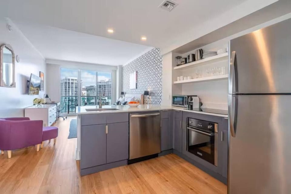 Fully equipped kitchen with modern appliances. Range, oven, dishwasher, refrigerator, microwave, and cooking/dining essentials.