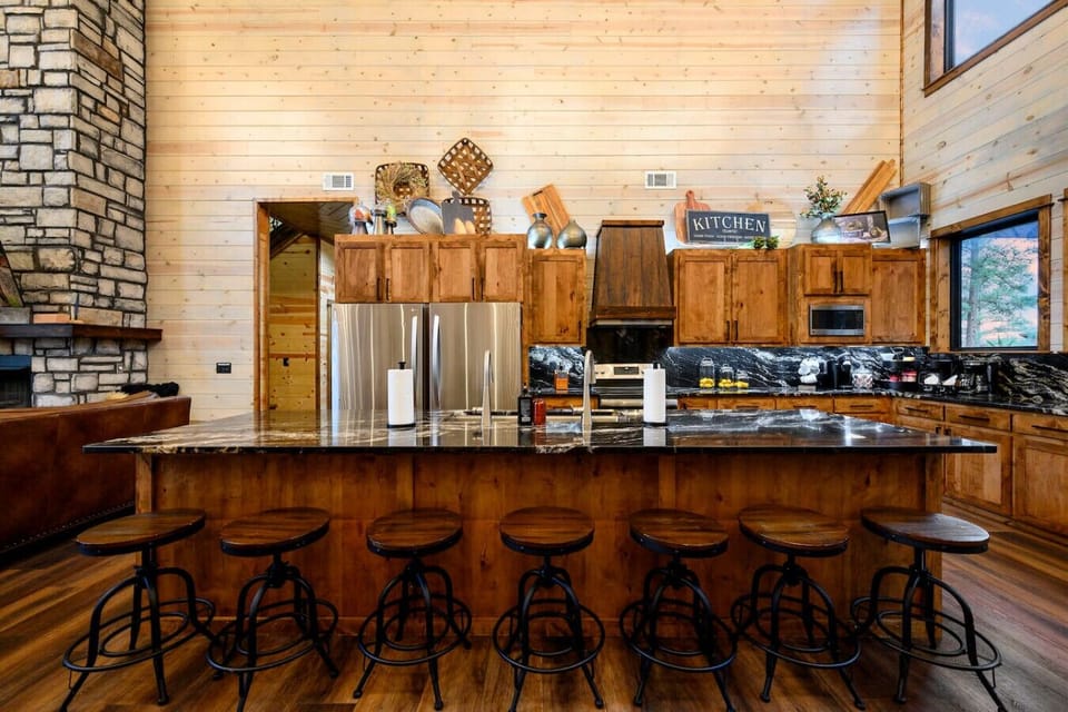This gorgeous log cabin kitchen has an island that seats seven and flows into the open living space with those amazing views.