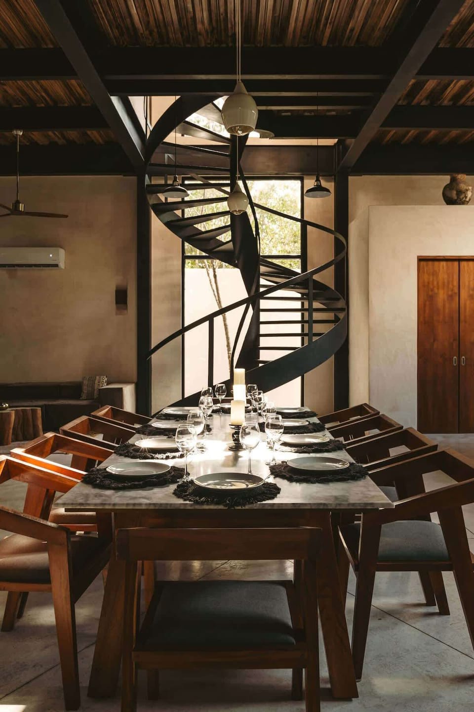 Modern and luxurious dining room located in a unique and harmonious space. Large windows cover the entire front wall, allowing a view of the entrance courtyard.