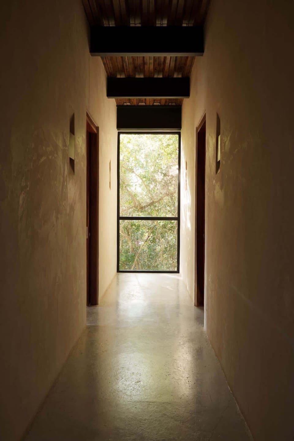 Minimalist space with a large window at the end that allows natural light to enter.