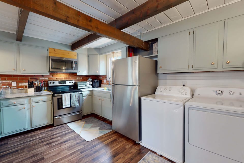 Fully equipped kitchen with stainless steel appliances and an in-unit washer and dryer conveniently located nearby for longer stays.