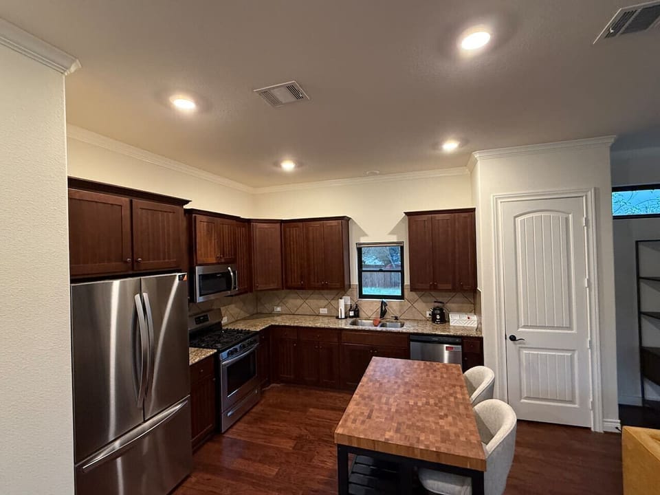 Fully equipped Guest House Kitchen featuring stainless steel, gas stove, butcher block island