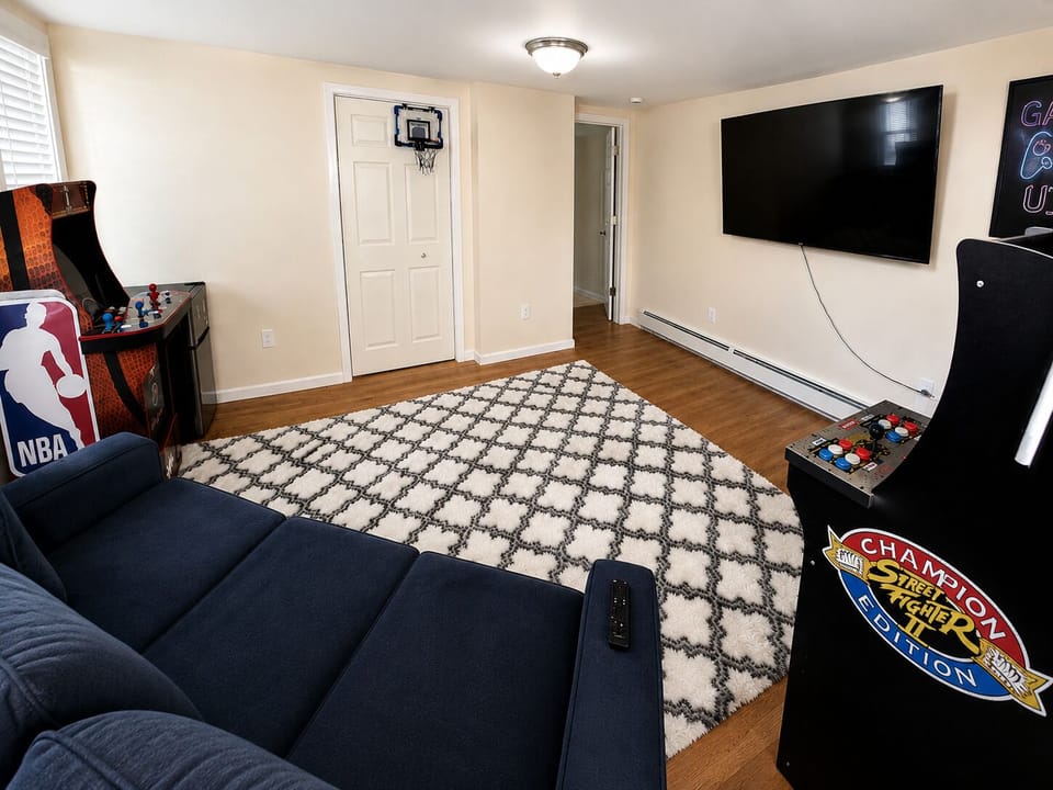 Large game room with arcade games, oversized Smart TV and comfortable sofa