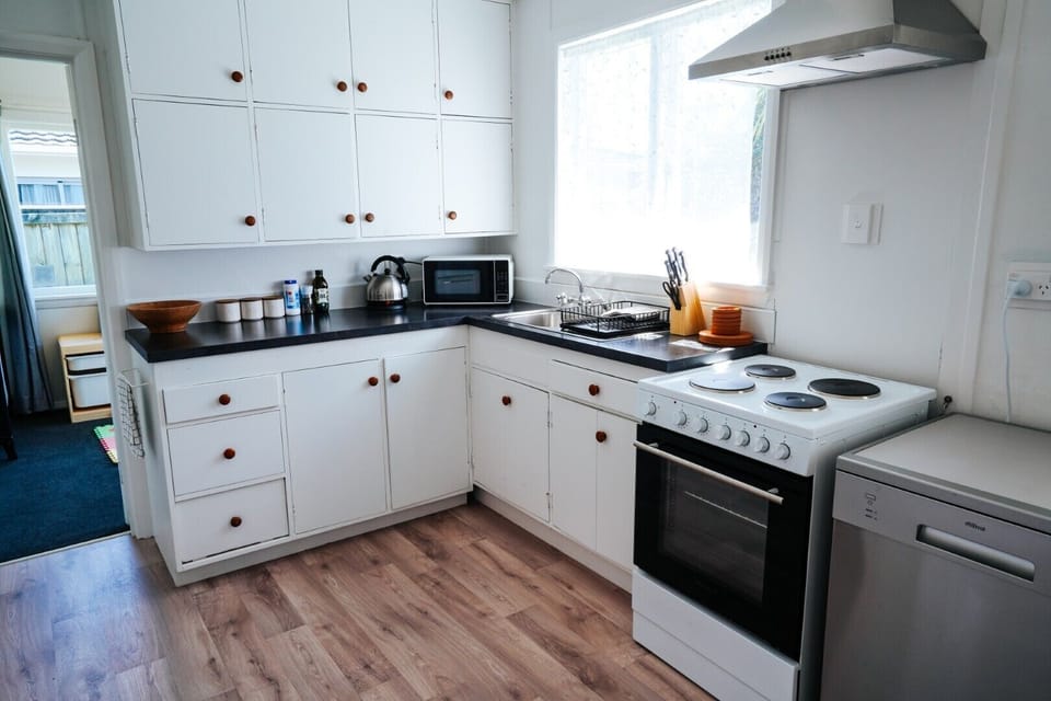 Fully equipped modern kitchen with appliances, ample counter space, and storage. Perfect for cooking meals and entertaining guests.
