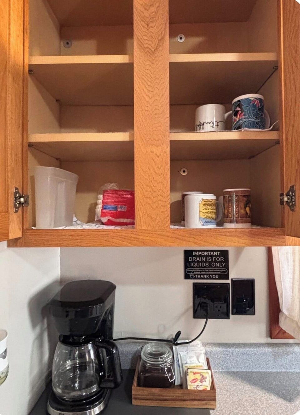 Drip coffee maker, cups, and tea for you to enjoy.