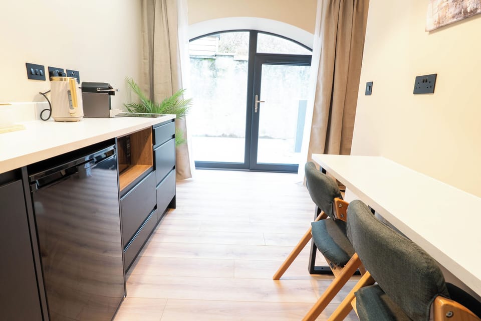 Modern kitchenette with coffee machine, fridge & prep space