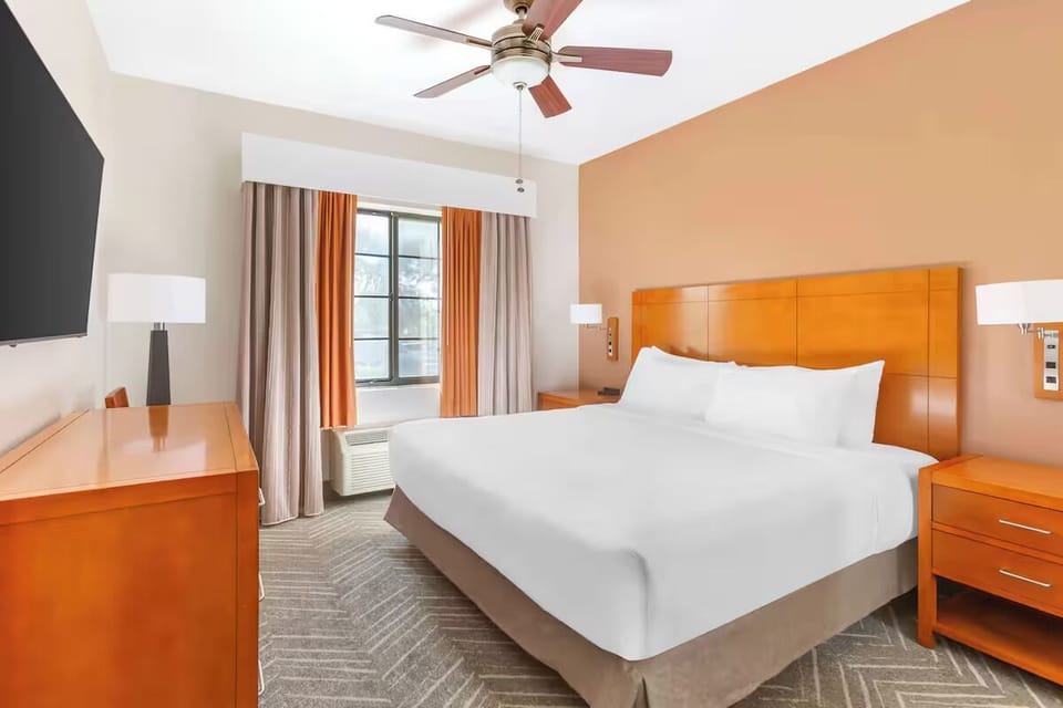 Unwind in a bright bedroom with TV and cooling comfort.