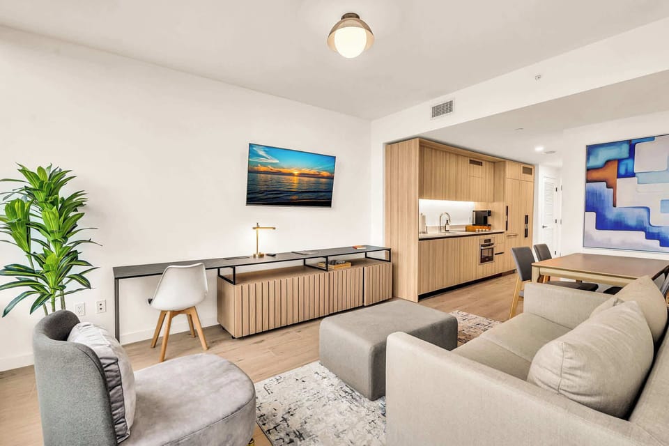 Experience modern comfort in this stylish living area with a sleek kitchen, cozy seating, and vibrant decor.