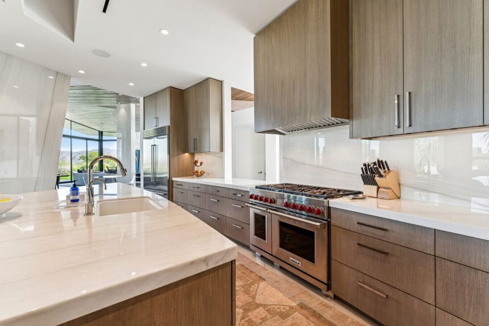 Chef’s kitchen w/ large island, bar seating & sleek wood cabinetry