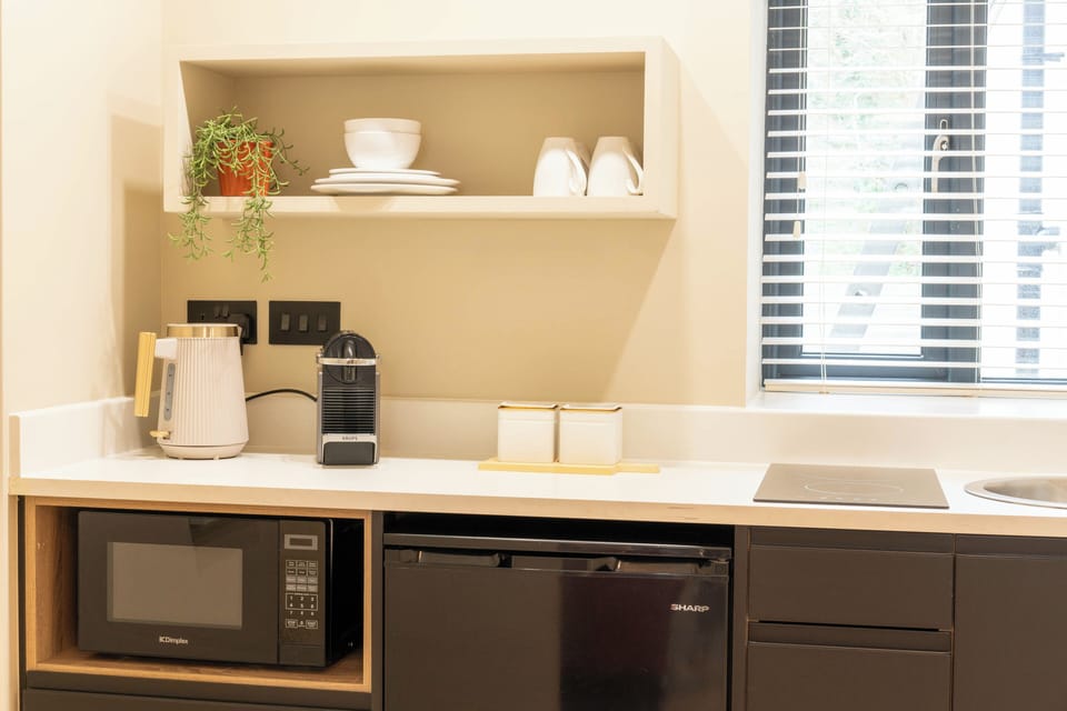 Neat kitchenette with Nespresso, fridge & handy worktop