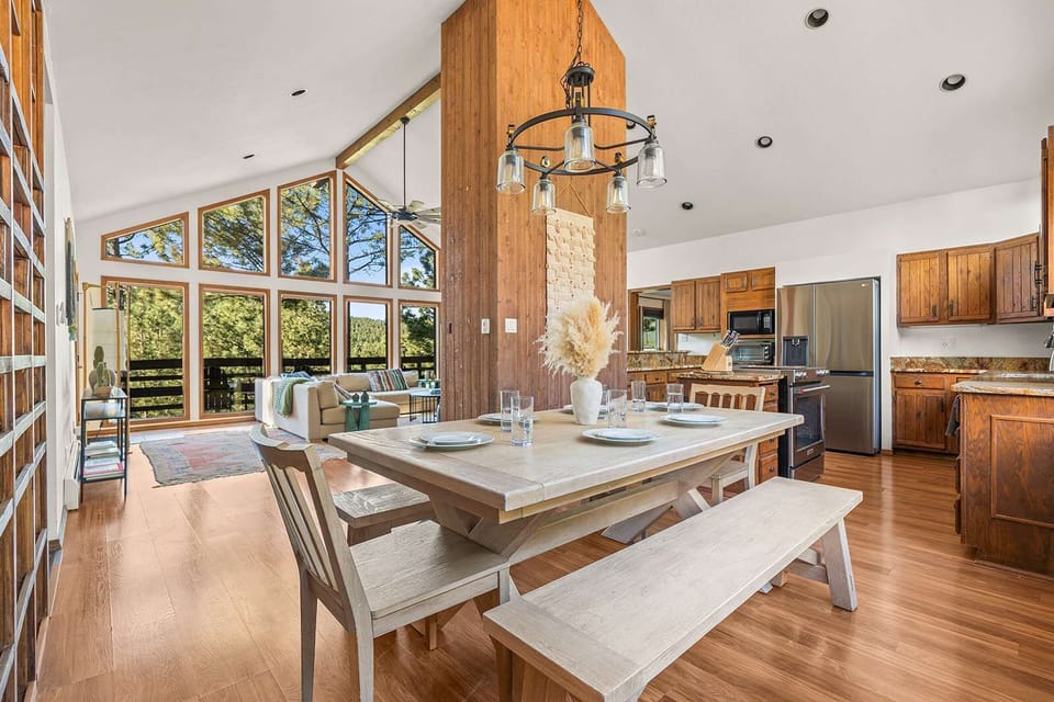 An open-concept dining nook flows straight into the kitchen, farmhouse table ready for a shared meal. - Open-Concept Dining - The Alta - Angel Fire, NM
