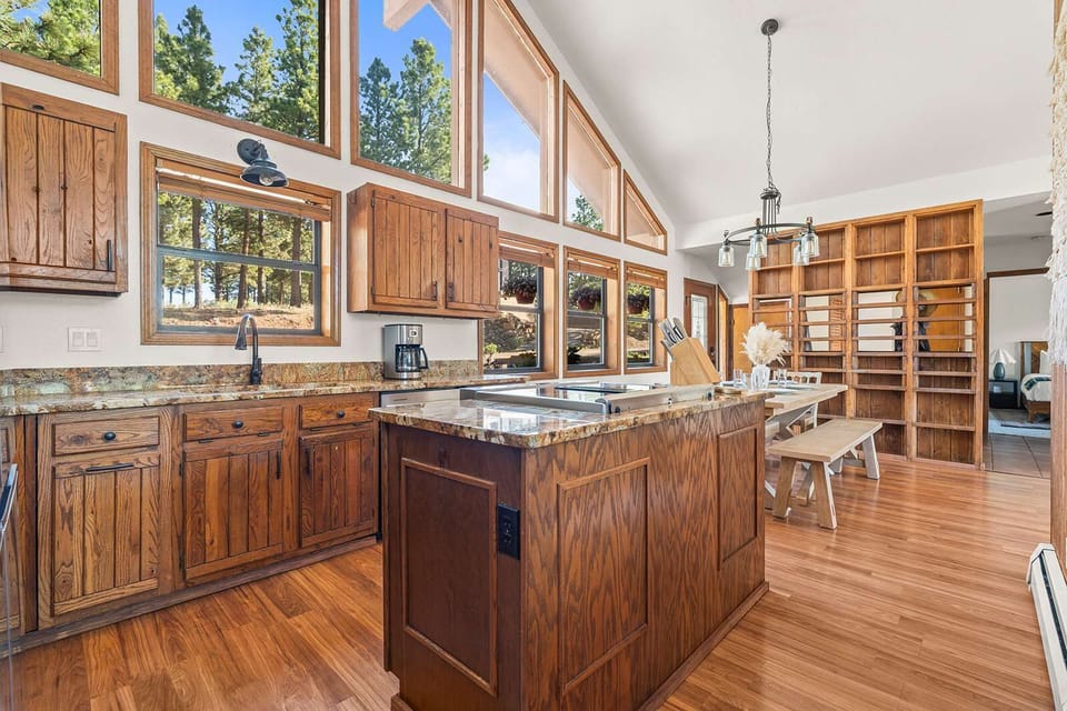 The kitchen opens straight onto a communal dining table beneath soaring, window-lined ceilings. - Kitchen to Dining - The Alta - Angel Fire, NM