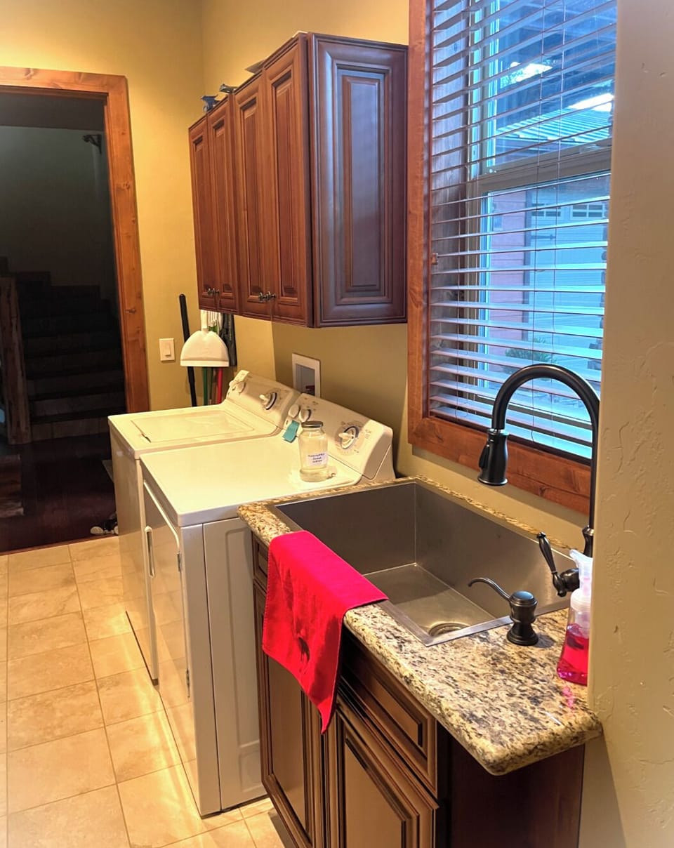 Spacious utility room with washer, dryer, and sink