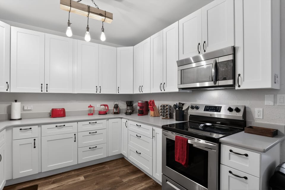 Bright kitchen with oven, microwave, kettle, and coffee station with multiple coffee maker options (Keurig, Nespresso, French Press, traditional) - modern & cozy