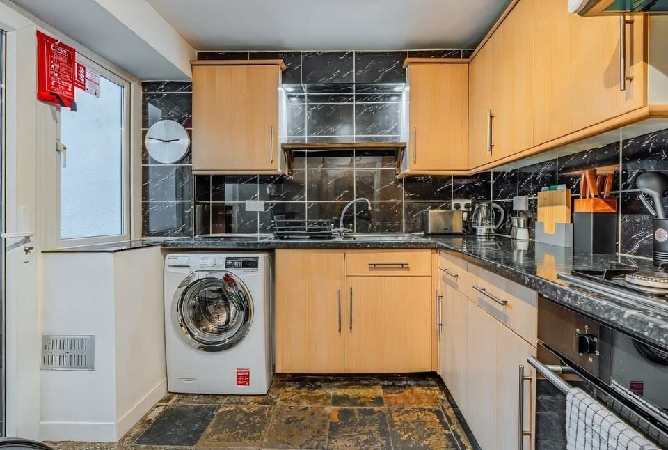 Fully equipped kitchen with oven, washer, and storage