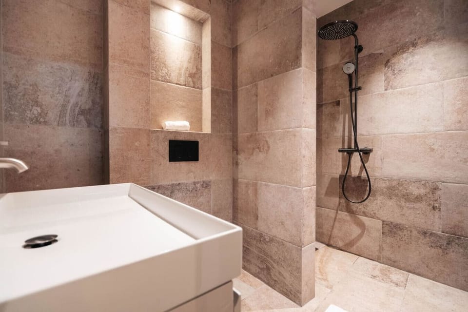 Spa-like bathroom with a rainfall shower and warm stone finishes.