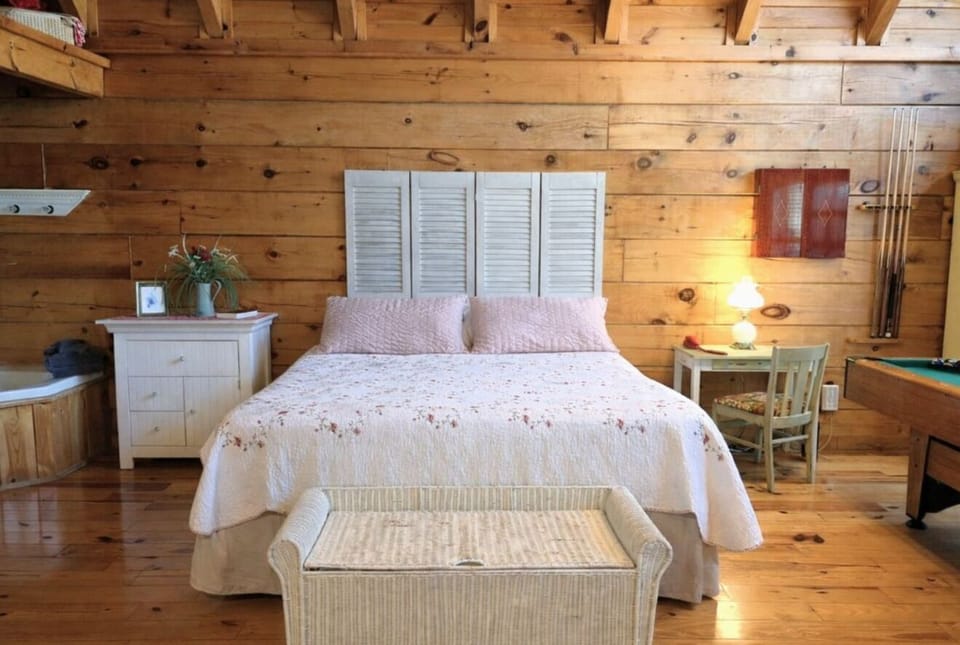 Elegantly styled king bedroom with crisp white furniture and soft lighting at Adorable Shut'er Inn in Pigeon Forge, Tennessee — a romantic couples retreat just minutes from Dollywood.