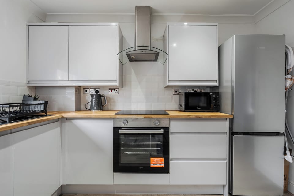 Fully equipped kitchen with everything needed for a comfortable stay. Includes fridge, microwave, kettle, dishwasher, and essential cookware—perfect for preparing meals or a relaxed breakfast before heading out.