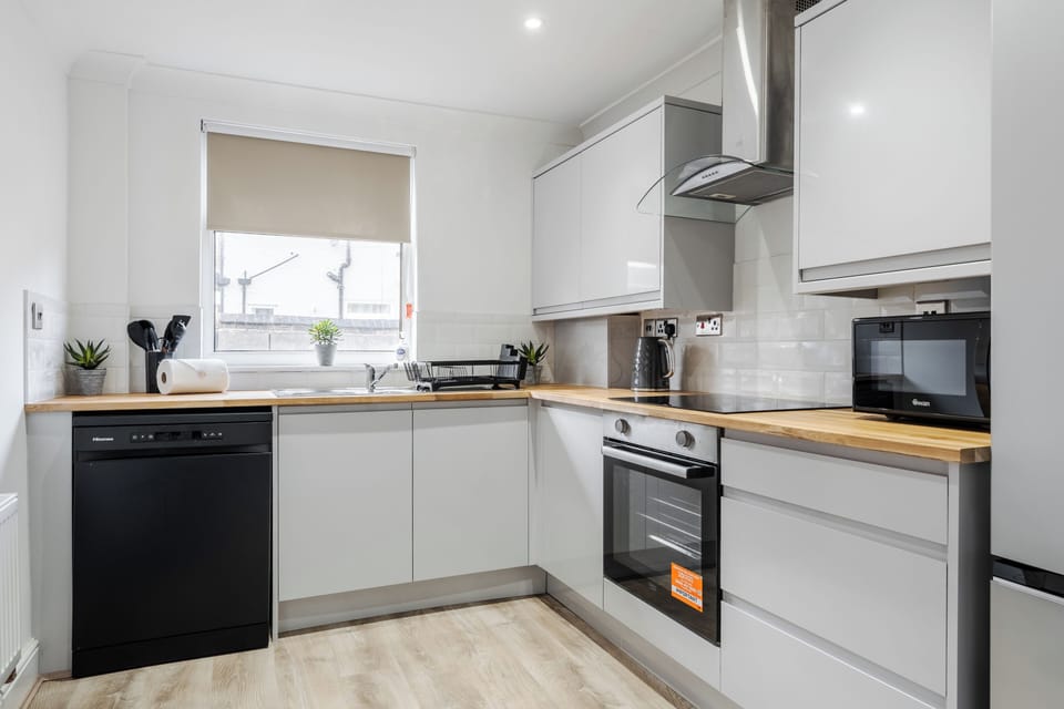 Fully equipped kitchen with everything needed for a comfortable stay. Includes fridge, microwave, kettle, dishwasher, and essential cookware—perfect for preparing meals or a relaxed breakfast before heading out.