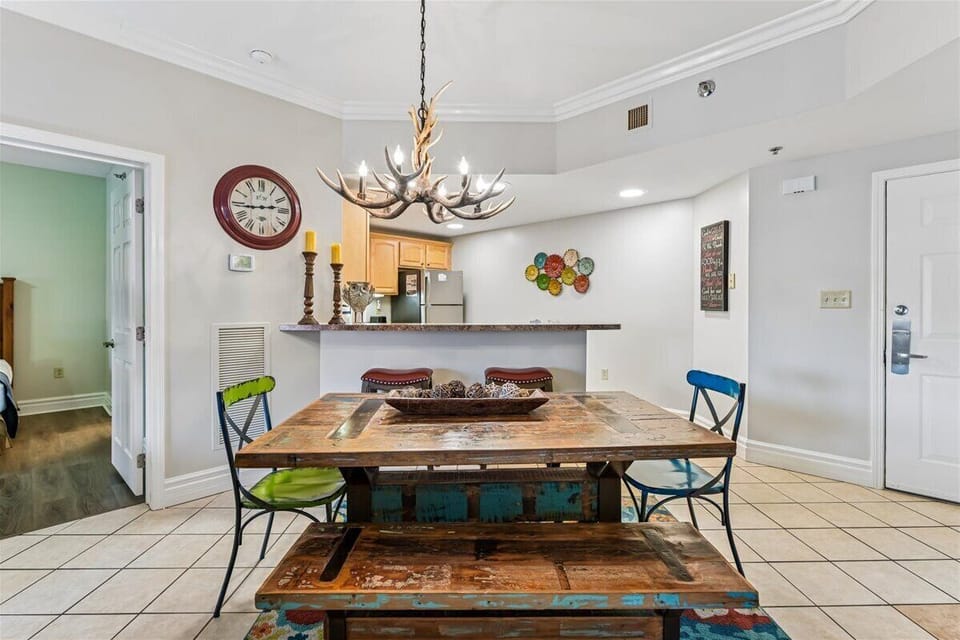 Gather around your rustic dining table beneath the striking antler chandelier, where memorable meals await in this charming space.