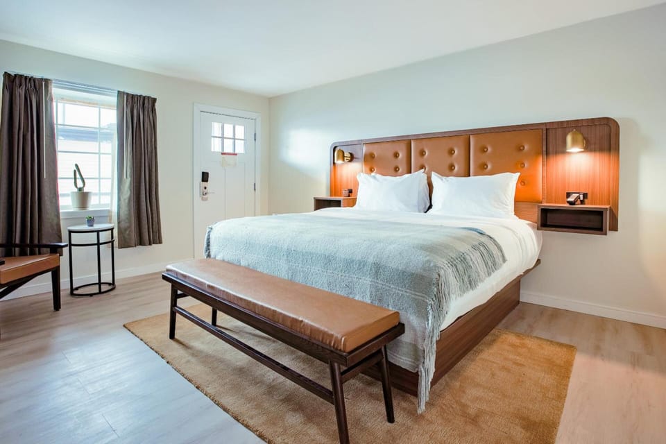 Unwind in a sunlit king bed with warm wood accents