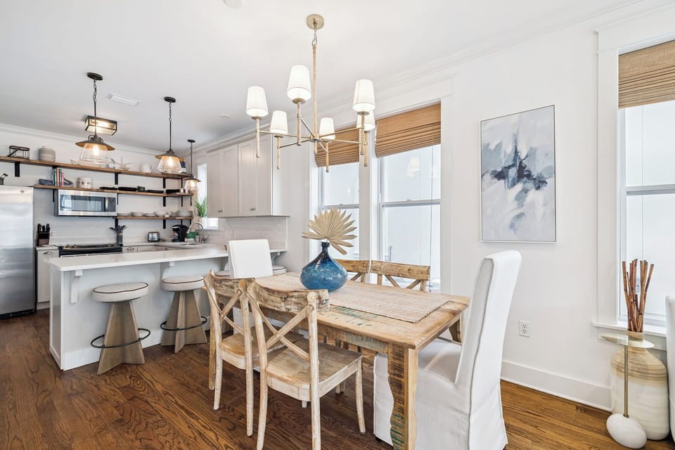 You'll love gathering in this bright, open dining space with its elegant chandelier and stylish kitchen perfect for cooking together.
