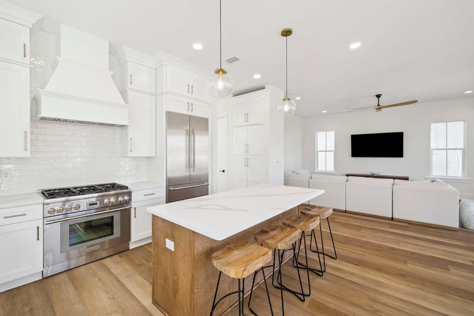 Your chef-worthy kitchen awaits with granite counters, gas range, and island seating flowing into the cozy living space.