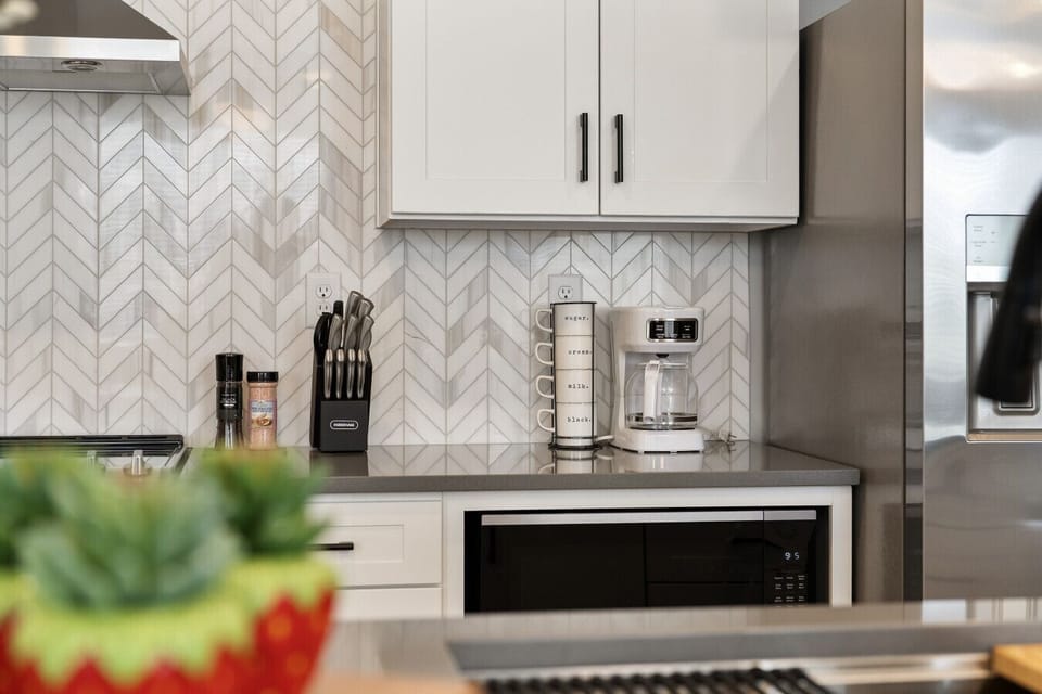 Stylish kitchen detail with coffee station, knife set, and herringbone backsplash