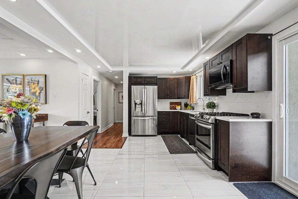 Sleek galley kitchen with stainless steel appliances and dark wood cabinetry in Ottawa