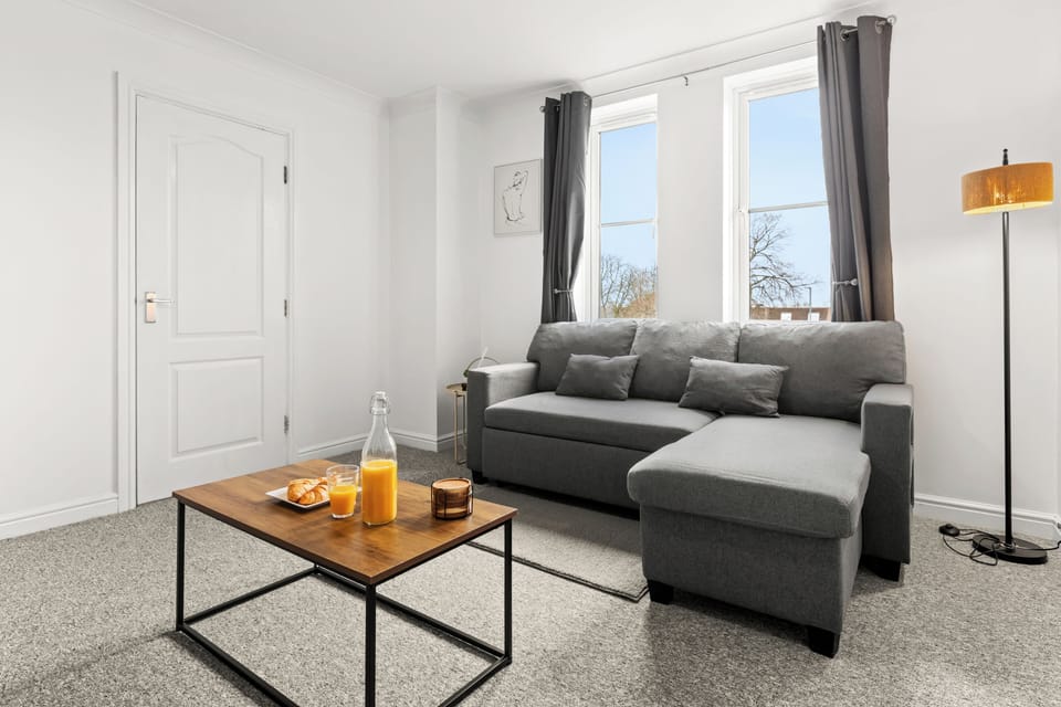 Bright modern lounge with cozy sofa, large windows, and stylish decor