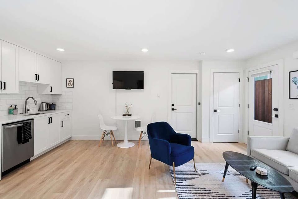 Sleek, all-in-one living space with kitchen, dining table & cozy seating—perfect for a simple, stylish stay.