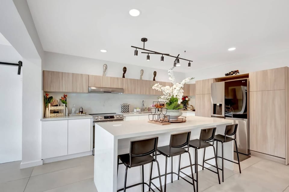 A bright, open-concept kitchen with a large island and bar seating. Designed for cooking and gathering, this space blends modern style with comfort for shared meals and conversations.