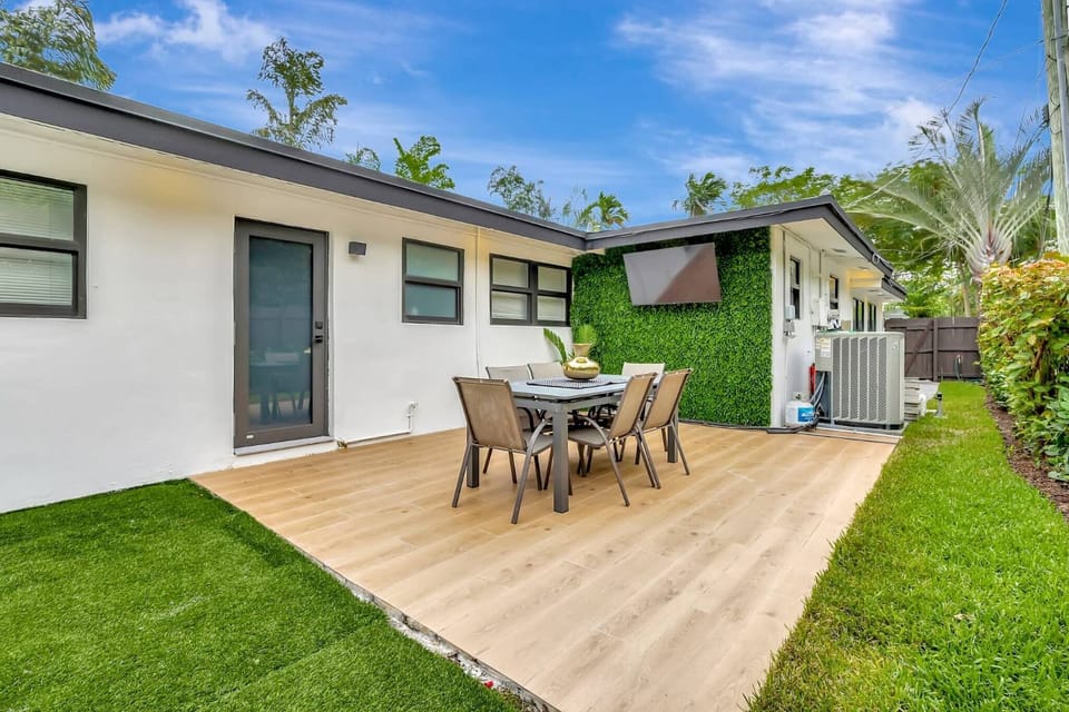 A private outdoor patio with dining space and fresh greenery, ideal for enjoying meals in the open air. The peaceful setting makes it perfect for relaxing afternoons and casual evenings.