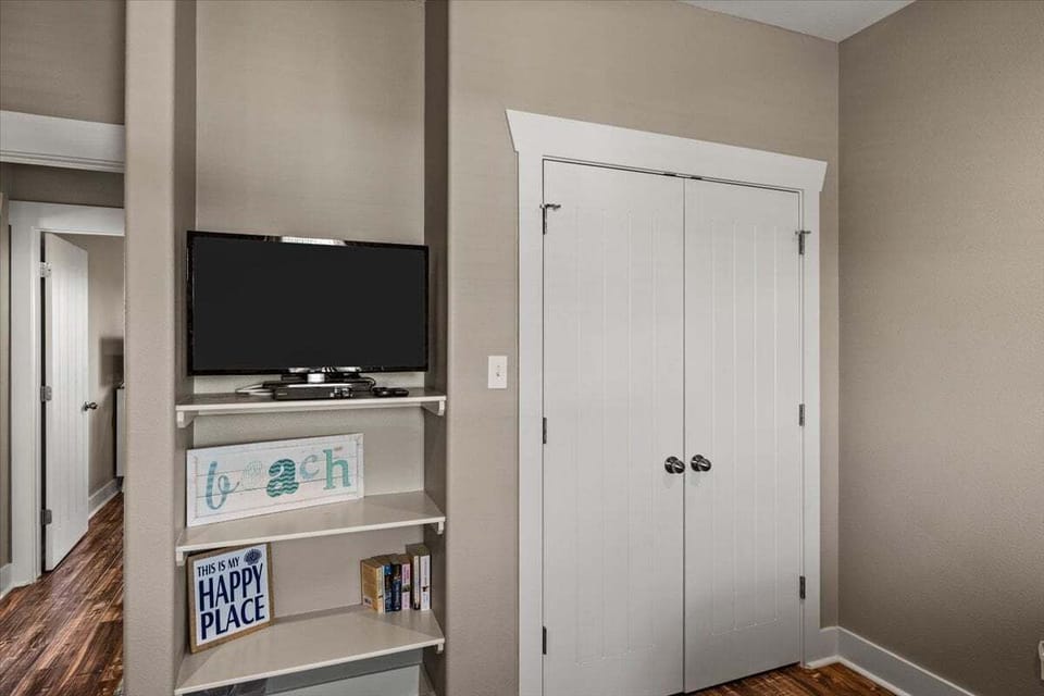 Entertainment area with TV and storage space, ideal for relaxing after a day at the beach.