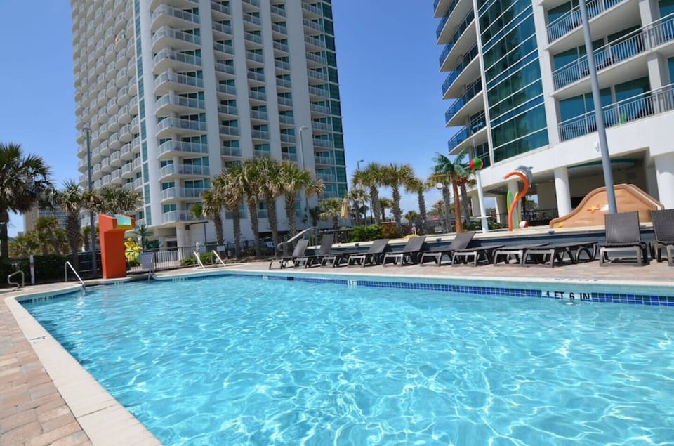 Relax by a sparkling outdoor pool with sun loungers and clear blue skies