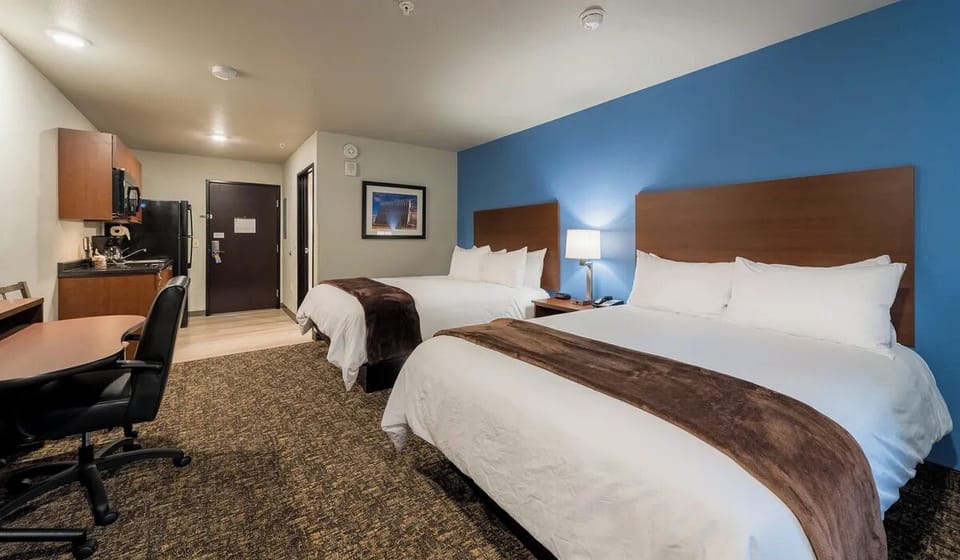 Sink into cozy double-queen beds in a calm, bright room.