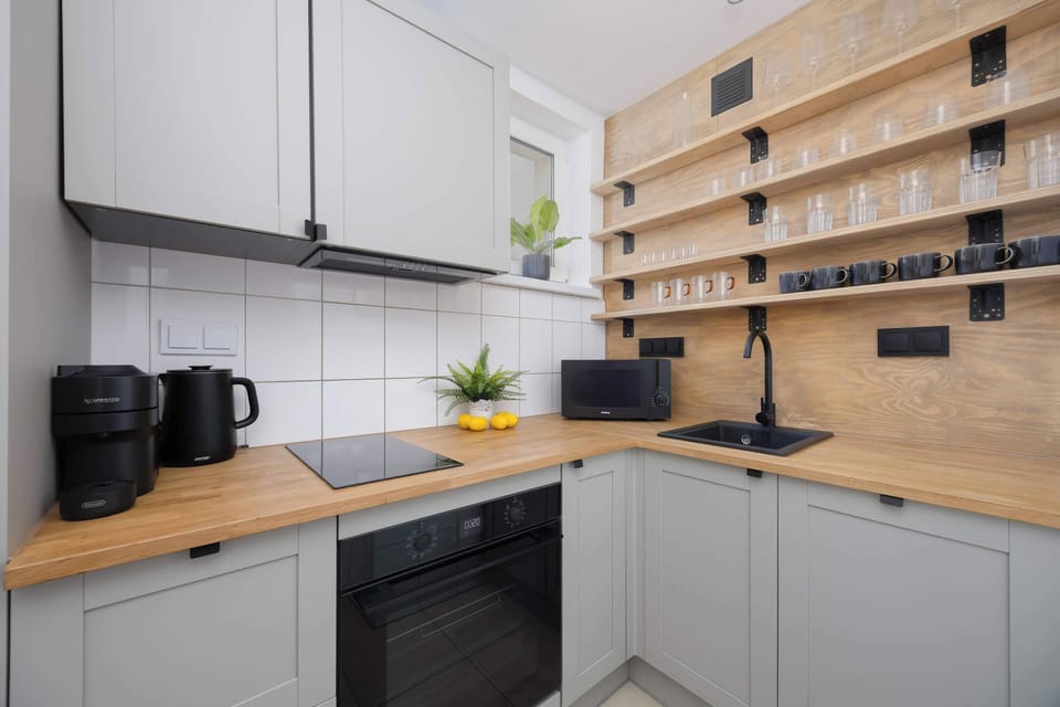 The L-shaped kitchen provides optimal space for meal preparation thanks to its wide countertop. Under-cabinet spotlights have been installed, perfectly illuminating the stovetop and sink.