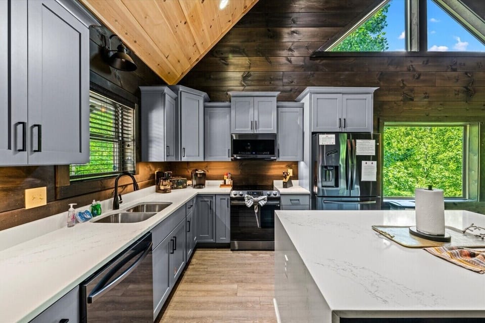 Prepare family favorites in a fully equipped kitchen featuring stainless appliances, generous counter space, and wooded views.