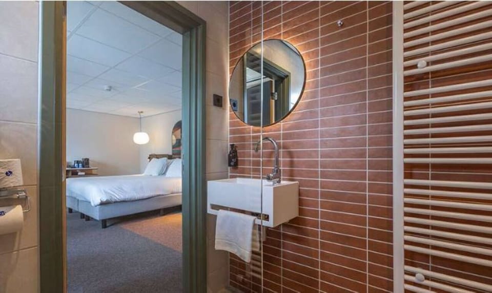 Step into a spotless bathroom with warm lighting and plush towels.