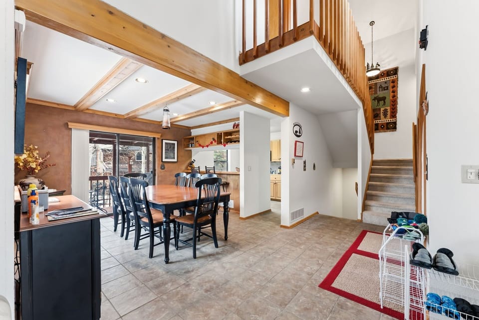 Gather around the dining table in this open-concept space where exposed beams and warm wood create rustic charm for your mountain getaway.