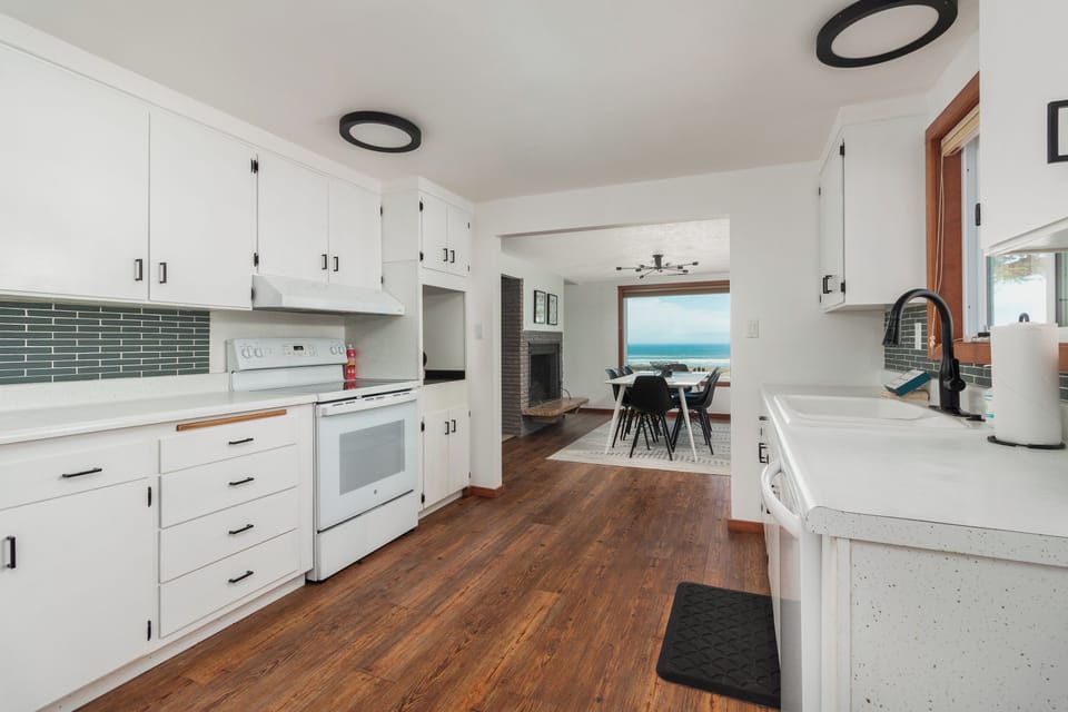 Cook with ocean views in this bright, fully-equipped kitchen featuring modern appliances and stunning sea vistas through the dining area.