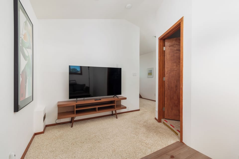 Unwind in your private entertainment space with a large flat-screen TV and stylish mid-century console.
