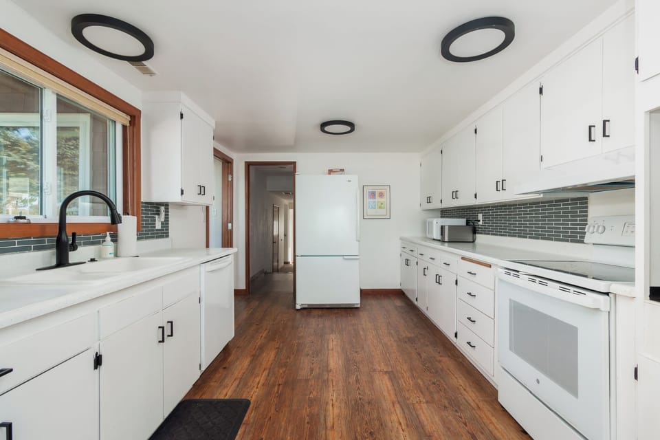 Your fully equipped kitchen awaits with pristine white cabinets, sleek countertops, and modern appliances for memorable meal preparation.