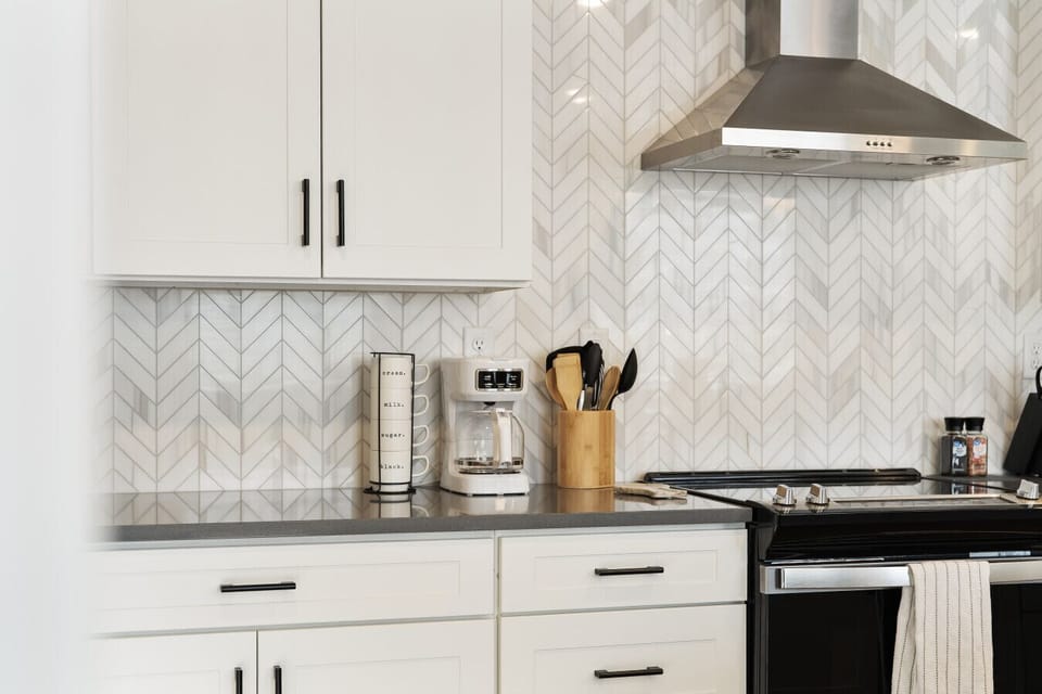 Kitchen with stove, hood, and decorative tile backsplash