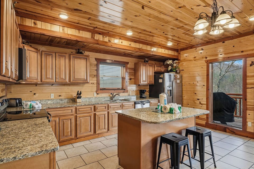 Your rustic mountain kitchen features granite counters, full appliances, and a cozy breakfast bar perfect for morning coffee together.
