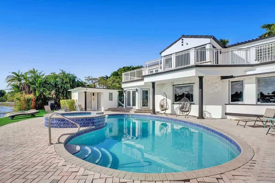 A pristine pool and spa area overlooking the tranquil river.