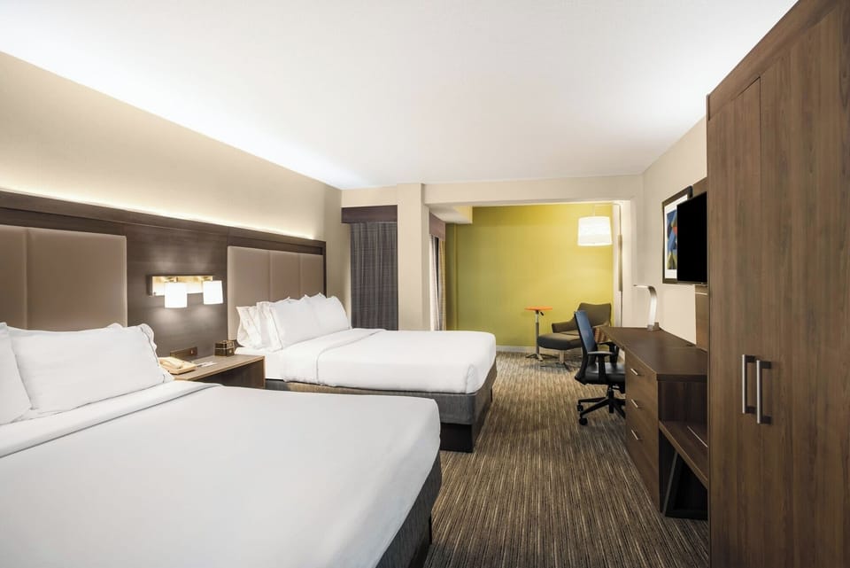 Unwind in a bright double-queen room with plush bedding.